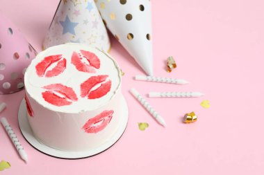 Renkli arka planda mumları ve şapkaları olan doğum günü pastası