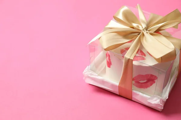 Colorful packaged cake decorated with red lips on a colored background