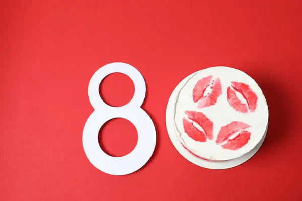 Number 8 and colorful packaged cake on a colored background