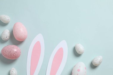 Paskalya dekoru konsepti. Paskalya tavşanı kulakları, çeşitli yumurtalar ve renkli arka planda Paskalya dekoru. 