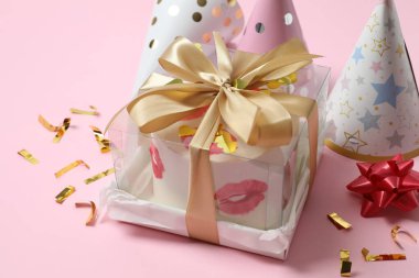 Renkli arka planda mumları ve şapkaları olan doğum günü pastası