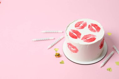 Renkli arkaplanda mumlar olan doğum günü pastası