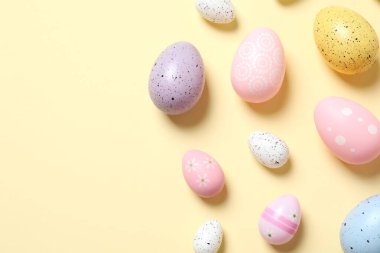 Paskalya dekoru konsepti. Pastel arka planda renkli yumurtaların en üstteki fotoğrafı 
