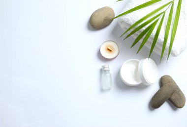 Spa salonu için sembolik nesnelerle kompozisyon. Kozmetik işlemler için taş terapisi özellikleri. Kavramsal görüntü, kayalar ve mum dengeyi temsil ediyor. Kapat, boşluğu kopyala, üst görünüm, arkaplan.