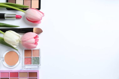 Beyaz arka planda taze laleleri olan dekoratif kozmetik seti.