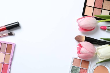 Beyaz arka planda taze laleleri olan dekoratif kozmetik seti.