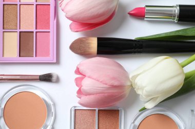 Beyaz arka planda taze laleleri olan dekoratif kozmetik seti.