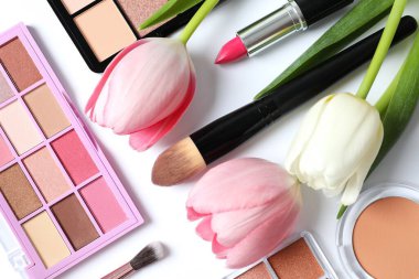 Beyaz arka planda taze laleleri olan dekoratif kozmetik seti.