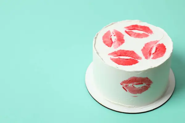 Birthday cake decotated with red lips on colored background