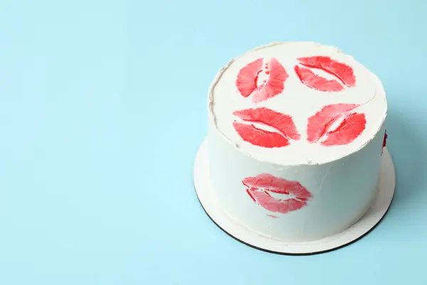 Birthday cake decorated with red lips on colored background