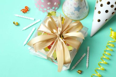 Renkli paketlenmiş pasta ve mumlar, renkli arka planda şapkalar.