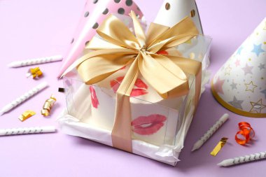 Renkli paketlenmiş pasta ve mumlar, renkli arka planda şapkalar.