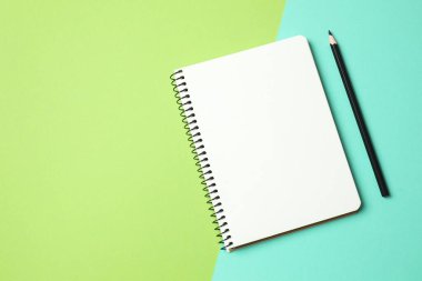 Renk arkaplanında kalem olan defter, metin için boşluk