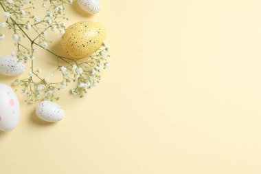 Paskalya dekoru konsepti. Renkli arka planda beyaz gypsophil ile renkli yumurtaların üst görünüm fotoğrafı ve metin için boşluk