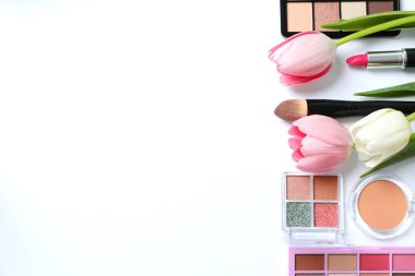 Beyaz arka planda taze laleleri olan dekoratif kozmetik seti.