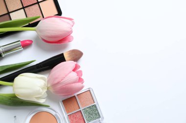 Beyaz arka planda taze laleleri olan dekoratif kozmetik seti.