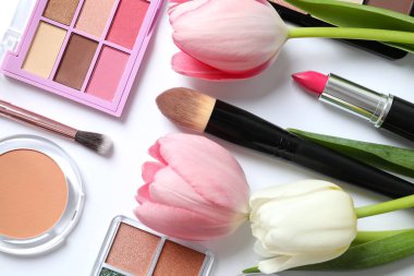 Beyaz arka planda taze laleleri olan dekoratif kozmetik seti.