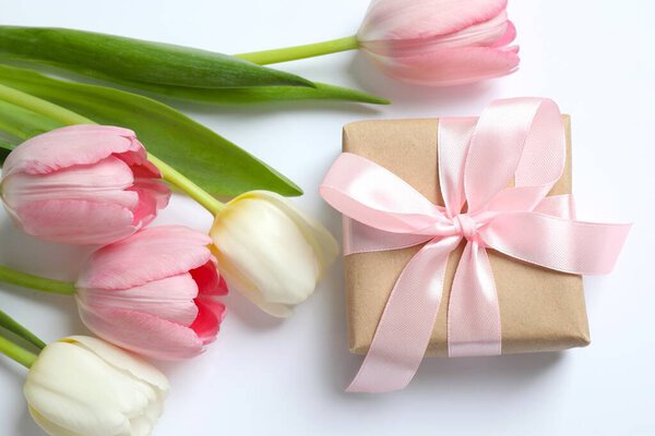 Beautiful tulips with a giftbox on white background