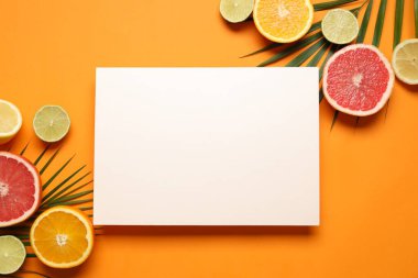 Beyaz kartla yazlık tropikal kompozisyon. Renkli arka planda yeşil palmiye yaprakları ve tropikal meyveler. Yaz kavramı. Düz konum, üst görünüm, kopyalama alanı