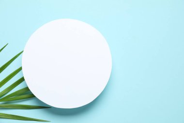 Renkli arka planda beyaz bir kart ile yeşil palmiye yaprakları