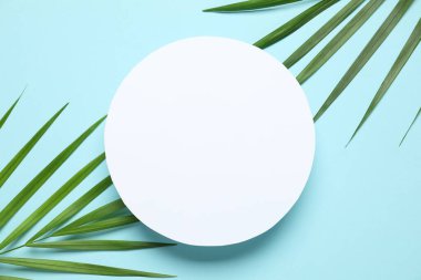 Renkli arka planda beyaz bir kart ile yeşil palmiye yaprakları