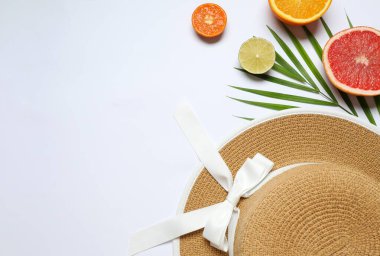 Yaz kompozisyonu. Meyveler, şapka, beyaz arka planda tropik palmiye yaprağı. Yaz kavramı. Düz konum, üst görünüm, kopyalama alanı