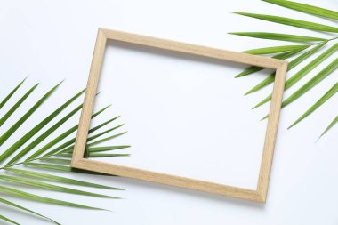 Beyaz arka planda ahşap çerçeveli yeşil palmiye yaprakları