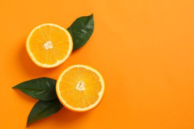 Renkli arka planda yaprakları olan taze turuncu narenciye.