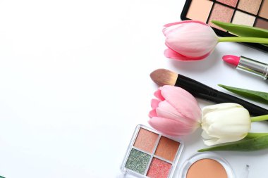 Beyaz arka planda taze laleleri olan dekoratif kozmetik seti.