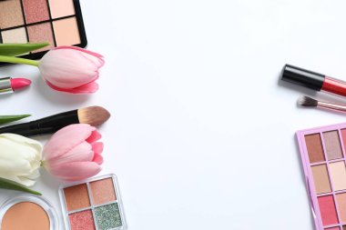 Beyaz arka planda taze laleleri olan dekoratif kozmetik seti.