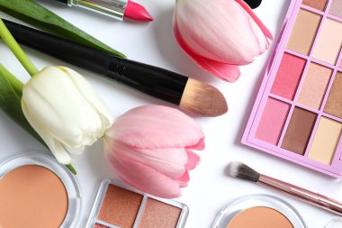 Beyaz arka planda taze laleleri olan dekoratif kozmetik seti.