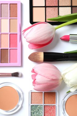 Beyaz arka planda taze laleleri olan dekoratif kozmetik seti.