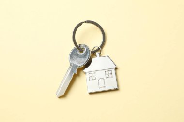 Renk arkaplan üzerinde ev şeklinde anahtarlığı olan metalik anahtar