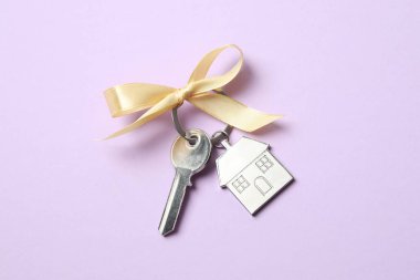 Beyaz arka planda altın fiyonklu ev anahtarı