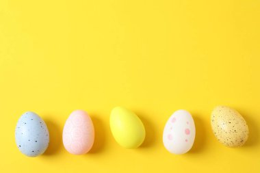 Renk arkaplanında Paskalya yumurtaları olan düz kompozisyon