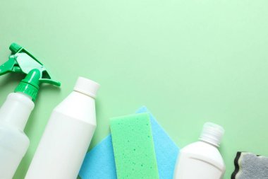 Gri arka planda birçok farklı ev temizleme ürünleri, üst görünüm