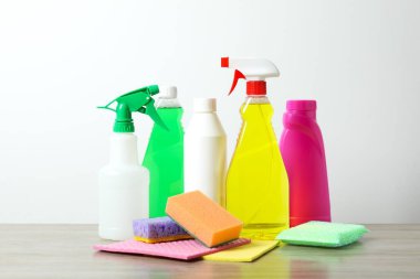 Gri arka planda birçok farklı ev temizleme ürünleri, üst görünüm