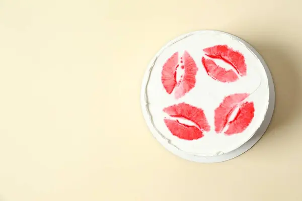 Colorful cake decorated with red lips on color background