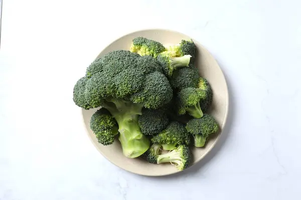 Fresh green broccoli in a bowl on light table