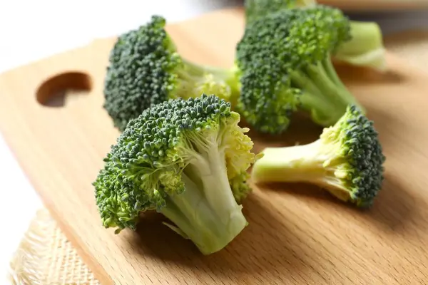 Fresh green broccoli in a bowl onon a cutting board