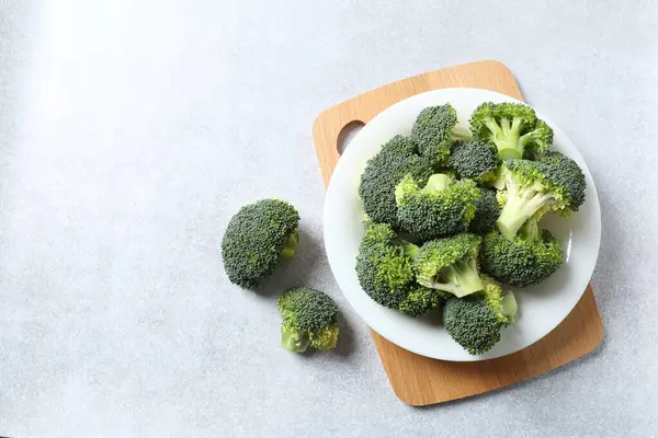 Fresh green broccoli in a bowl on light table
