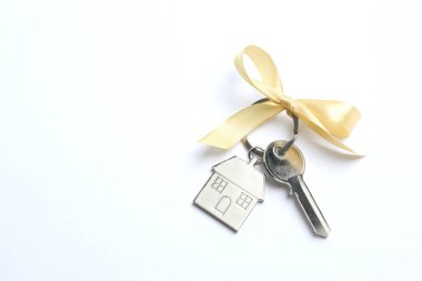 Metallic key with keychain on color background clipart