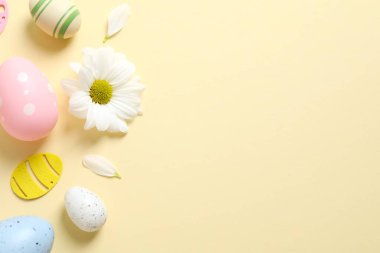Paskalya yumurtaları ve çiçeklerle süslenmiş arka plan, üst görünüm