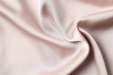 Bej ipek saten. Parlak pürüzsüz kumaş. Yumuşak kıvrımlar. Tasarım için alanı olan lüks bir arka plan. Düz masa, üst görünüm