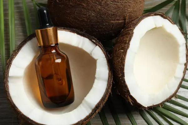 Skin care with facial serum. Glass bottle with pipette on a wooden background. Dry skin care product. Coconut essential oil moisturizing the skin of the body