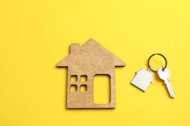 Anahtarlığı olan metal anahtar ve arka planda ahşap ev