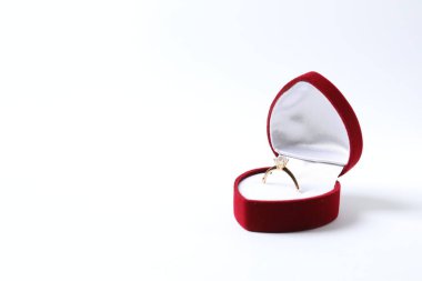 Zengin kırmızı kadife bir kutuda büyük elmas taşlı güzel, parlak altın bir nişan yüzüğü. 