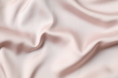 Bej ipek saten. Parlak pürüzsüz kumaş. Yumuşak kıvrımlar. Tasarım için alanı olan lüks bir arka plan. Düz masa, üst görünüm