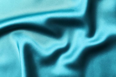 İpek saten turkuaz rengi. Parlak pürüzsüz kumaş. Yumuşak kıvrımlar. Tasarım için alanı olan lüks bir arka plan. Düz masa, üst görünüm