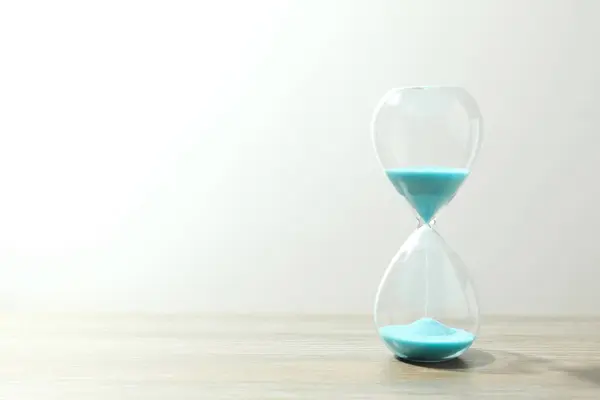 Modern hourglass on the table. Hourglass time concept for business deadline, urgency and outcome of time.
